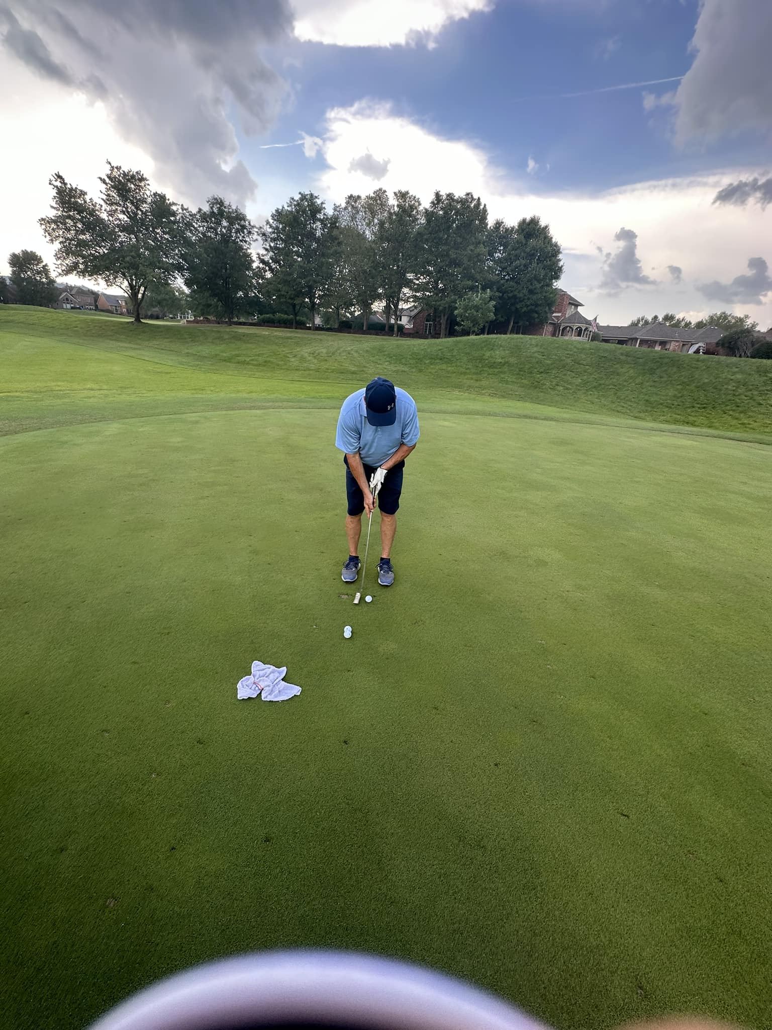 A golfer lining up for a put.