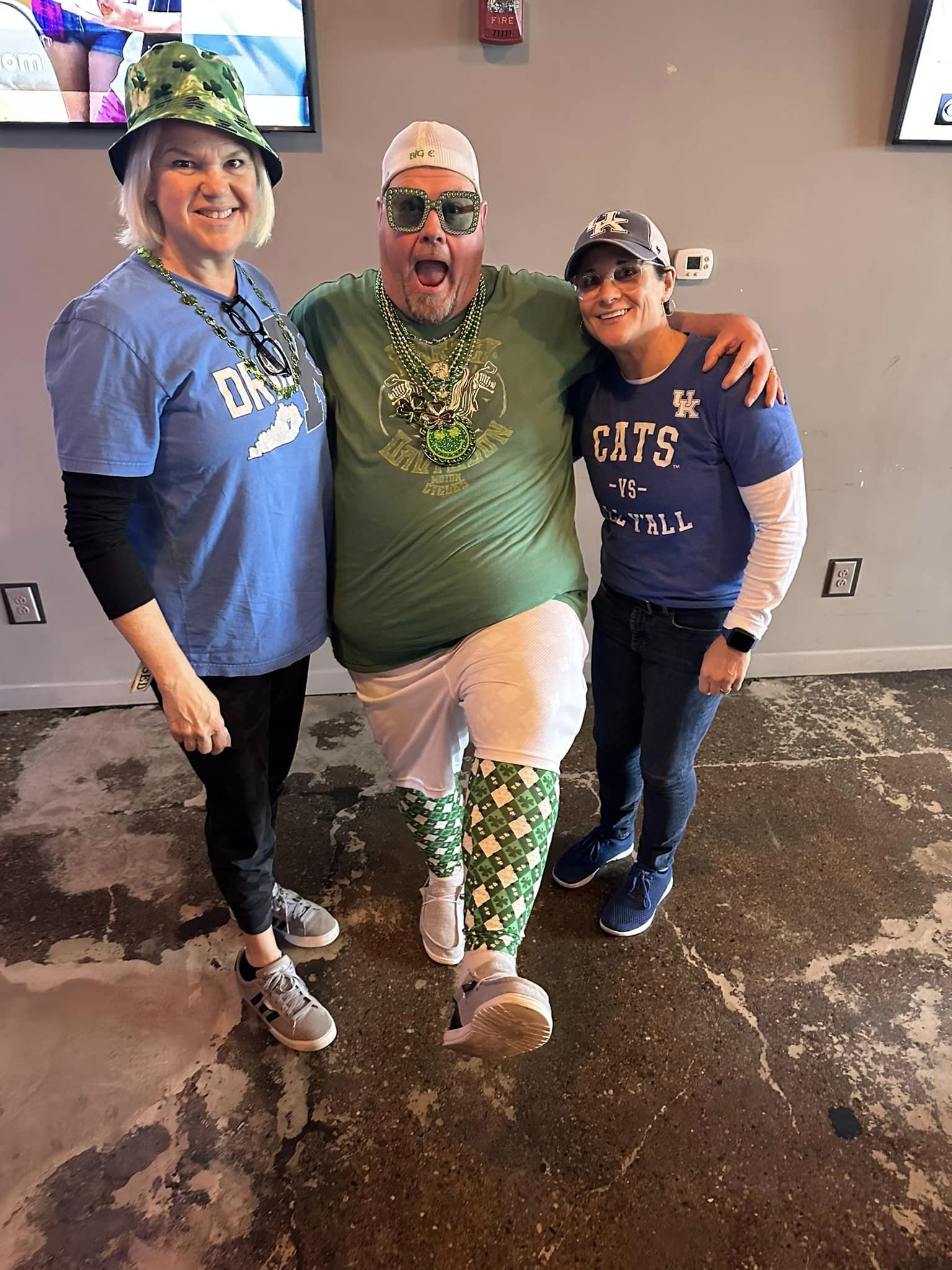 Three people smiling and dressed for St. Patty's Day